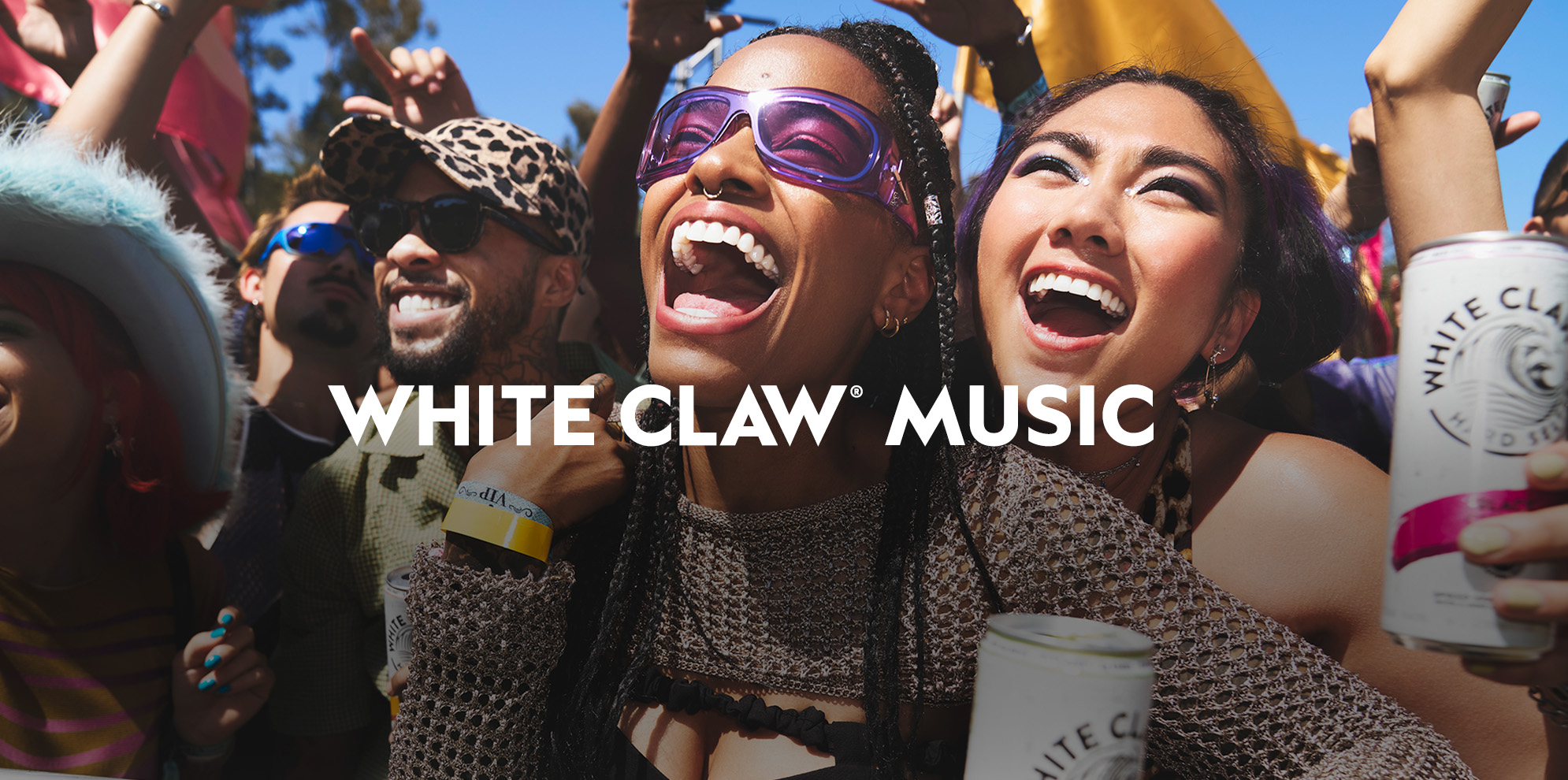 A lively crowd enjoys an outdoor music event, with smiling friends holding White Claw cans. Large text across the image reads “White Claw Music.”